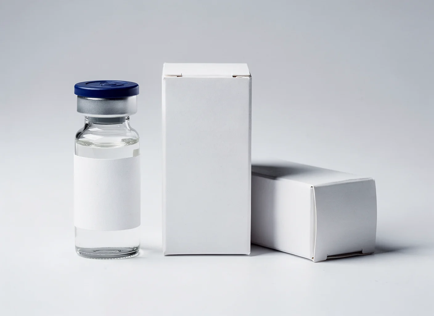 Blank vial and two blank folding cartons ready for a client's artwork